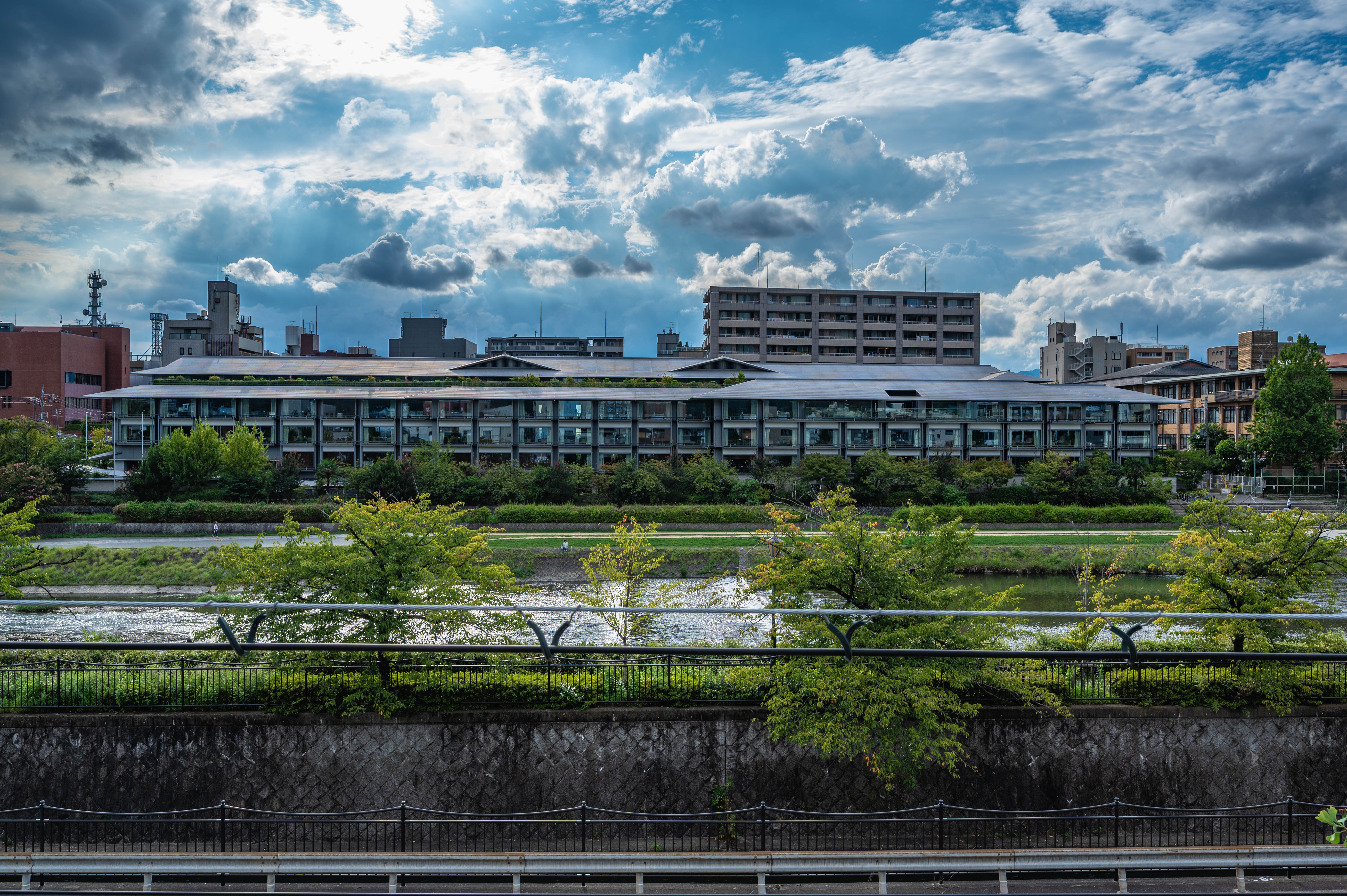 Scenic Kamo River view with lush green banks and dramatic sky